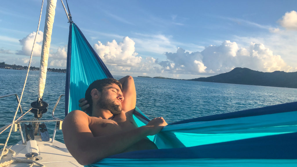 Pedro sleeping on a hammock in the bow of the boat