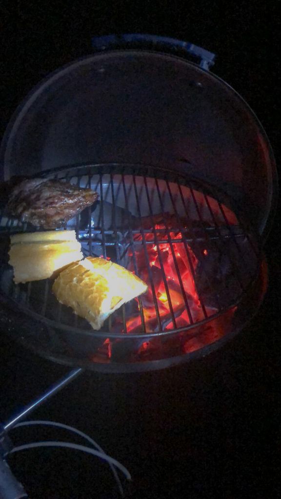 Lit Barbecue with beef on the stern of the boat